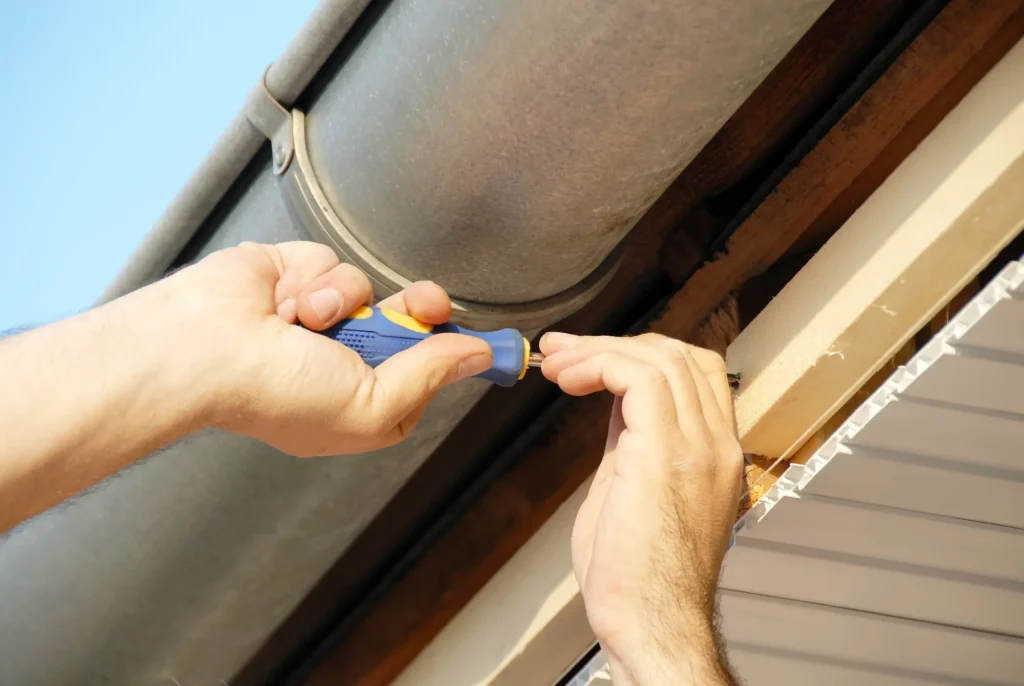 man fixing common reason for leaky gutters